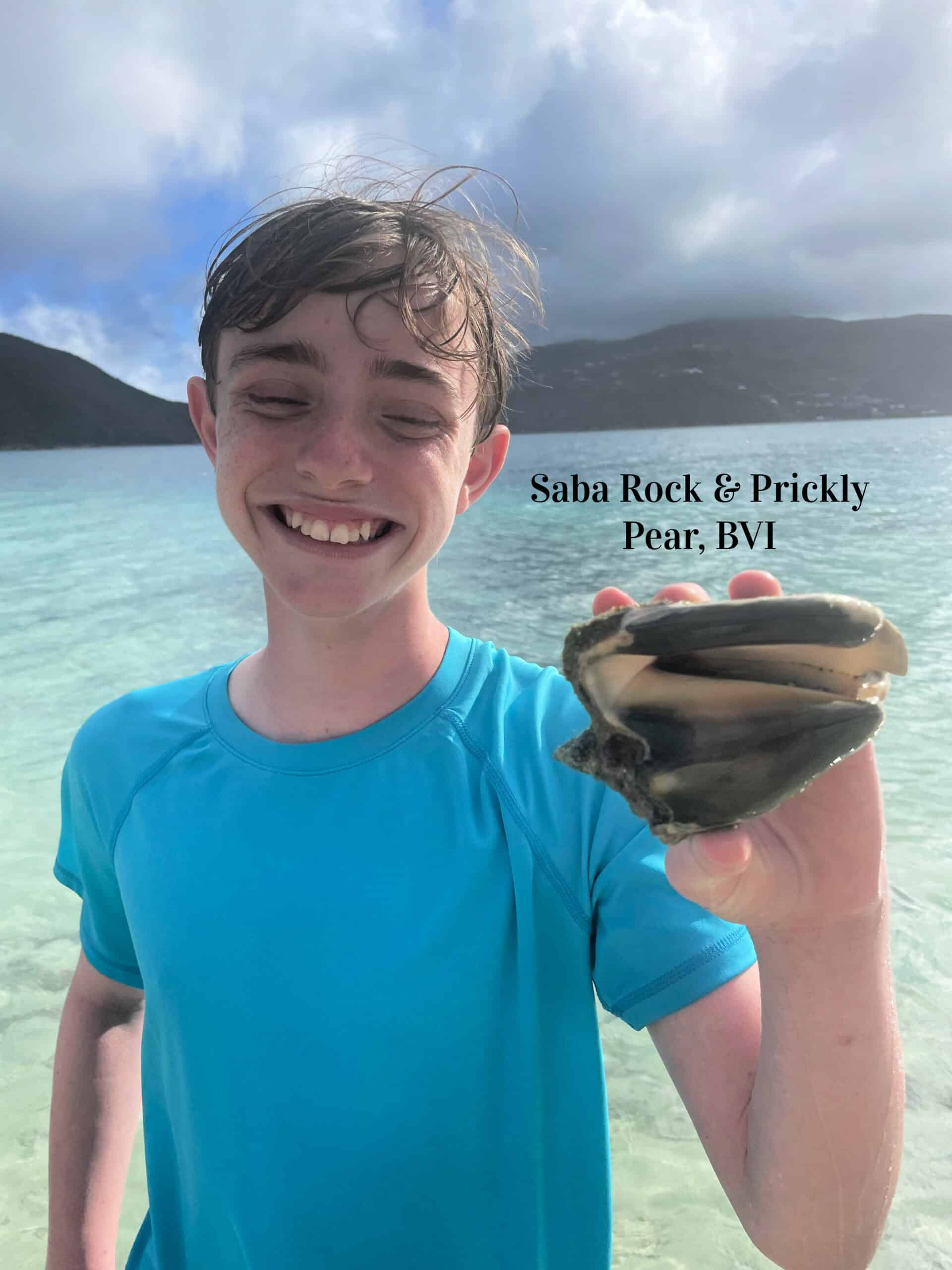 Young guest holding a prickly pear at Saba Rock BVI during a Sailaquanimity family catamaran charter