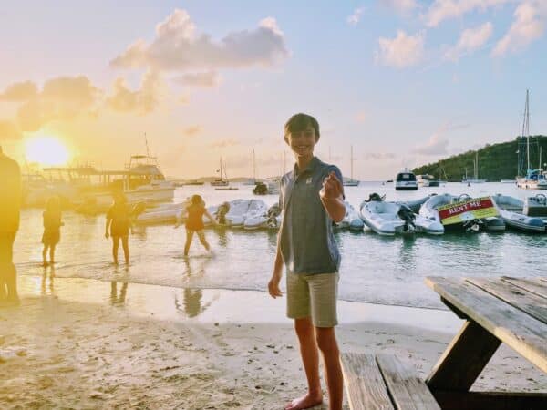 little boy carrying a shell in the BVI chartering the caribbean islands