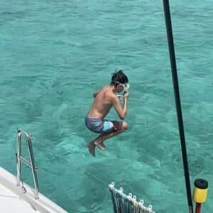 private yacht charter adventure kid jumping off side of boat