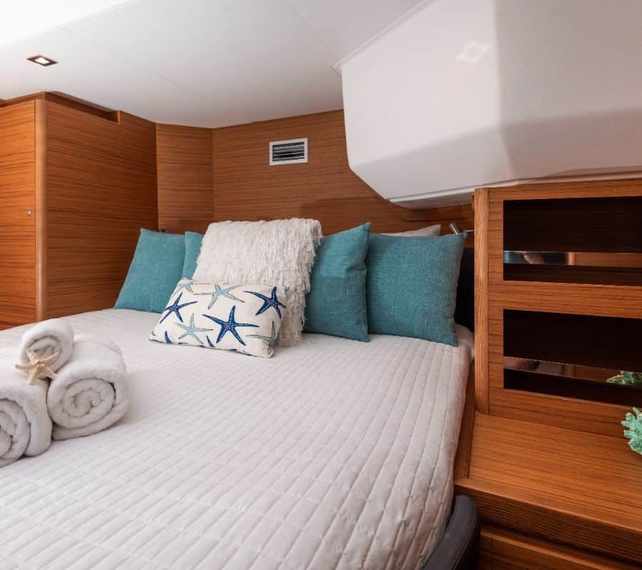 Private queen guest cabin aboard Aquanimity Dufour 48 catamaran with premium wood finishes