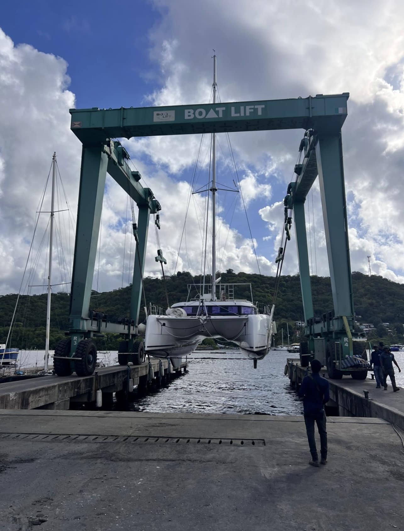 Aquanimity, a Dufour 48 catamaran, lifted out of the water by a travel lift crane for seasonal haul-out maintenance